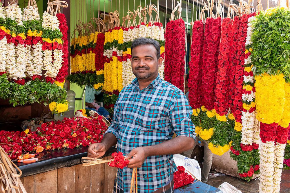Ein Händler auf dem farbenprächtigen Blumenmarkt von Madurai