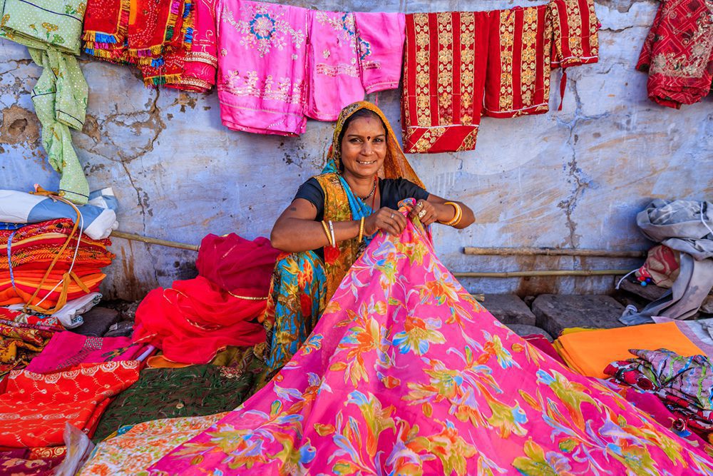 Entdecken Sie das farbenfrohe Indien auf einer Rajasthan Rundreise: bunte Stoffe auf einem Basar in Jodhpur
