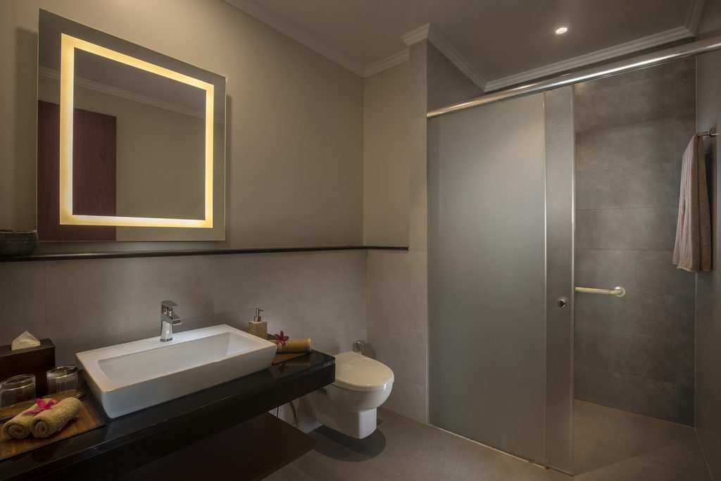 Das elegante Badezimmer eines Astha Zimmers im Amal Tamara vereint moderne Ausstattung mit warmer Atmosphäre.
