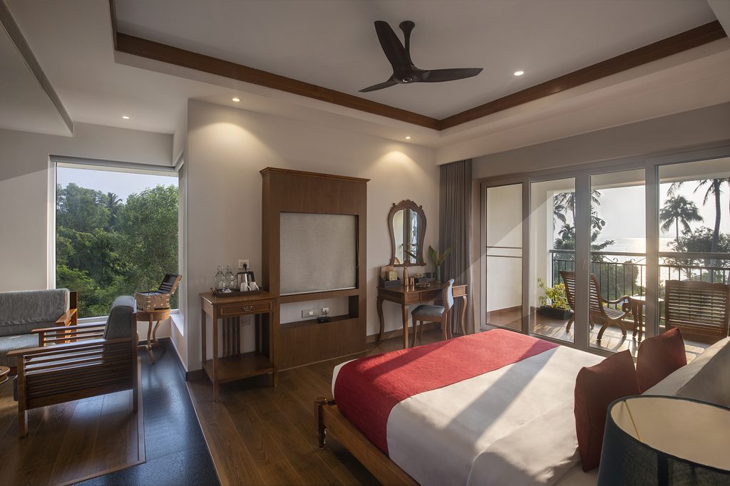 Ein geräumiges Ekta Zimmer im Amal Tamara Resort mit Balkon und Blick auf das Meer und die Palmenwipfel.