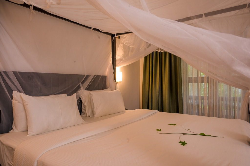 Die Ayur Villa im Ayur On The Beach Nattika bietet ein romantisches Himmelbett mit Moskitonetz und natürlicher Dekoration.