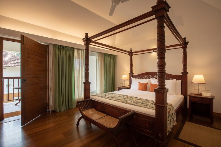 Elegantes Himmelbett-Schlafzimmer der Rasayana Suite im Kalari Rasayana Resort mit traditionellen Holzelementen.