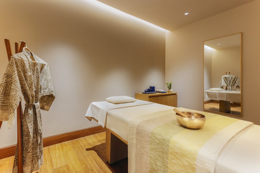 Ein ruhiger Behandlungsraum im Six Senses Vana lädt mit Massageliege und Klangschale zur Entspannung ein.